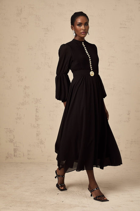 A black pleated midi dress with button front closure and a sleek silhouette