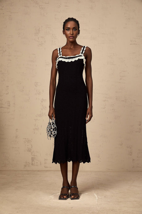 A black sleeveless midi dress with a crochet knit pattern throughout the garment