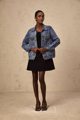 A blue denim jacket adorned with sparkling rhinestones featuring the name Valerie