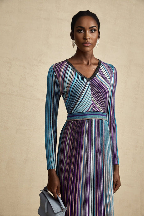 A blue metallic midi dress with pleated design named Mathilde featuring a shimmering fabric and flowing silhouette