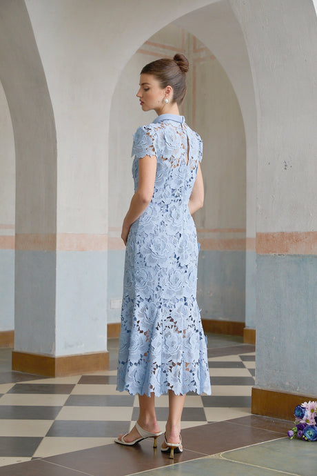A blue midi dress with delicate floral lace applique details covering the bodice and skirt creating an elegant and romantic look