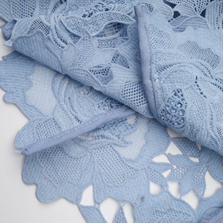 A blue midi dress with floral lace appliqués and a delicate floral pattern throughout the fabric
