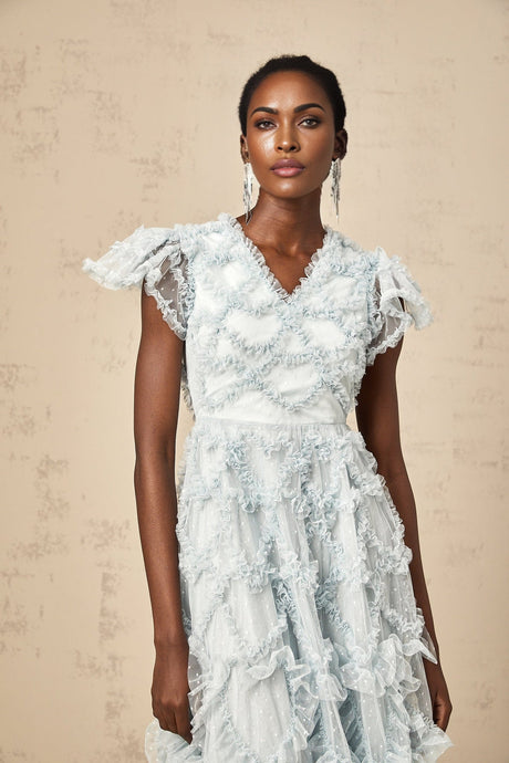 A blue midi dress with ruffled details and small dot pattern named Corinna