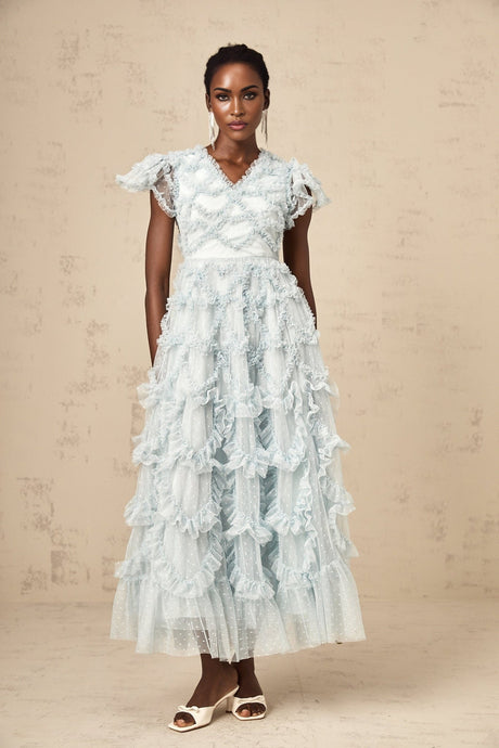 A blue midi dress with ruffled details and small polka dot pattern named Corinna