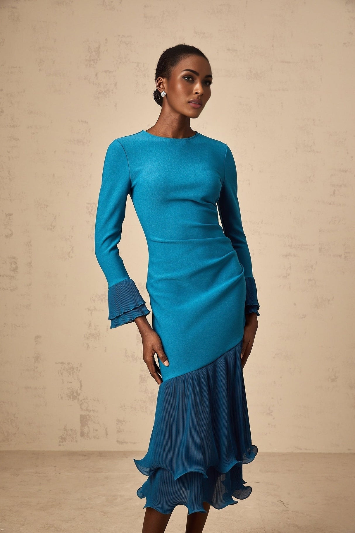 A blue midi dress with ruffled trim and panels featuring a feminine silhouette and delicate details