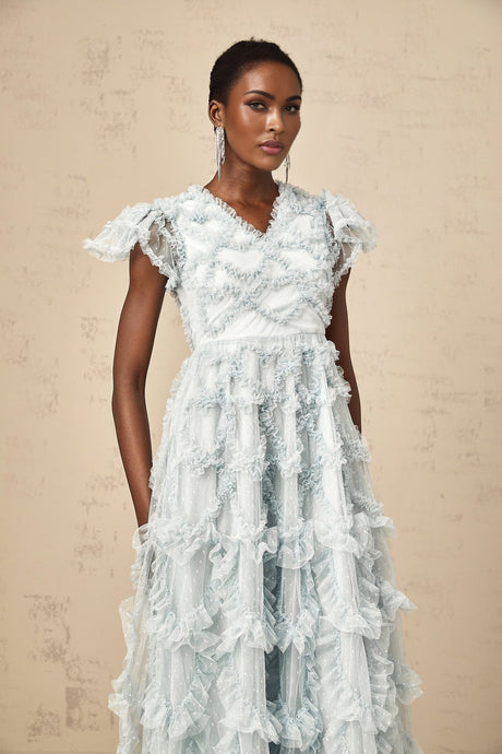 A blue midi dress with ruffles and small dot details named Corinna