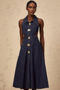 A dark blue denim midi dress with cut out details on a plain background