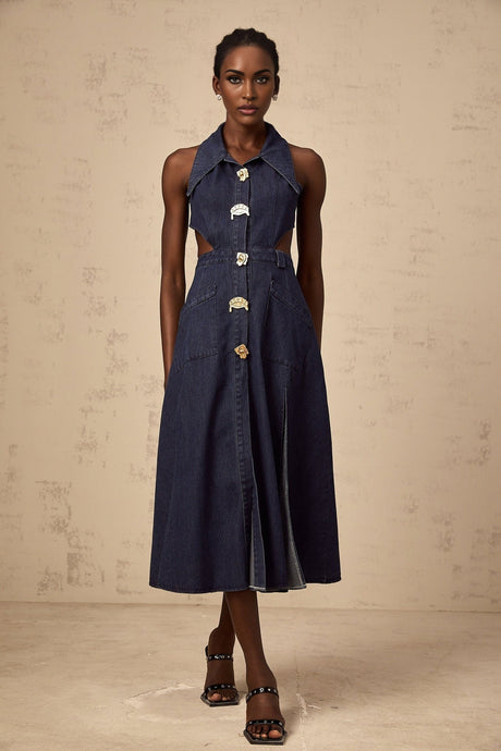A dark blue denim midi dress with cut out details on a plain background