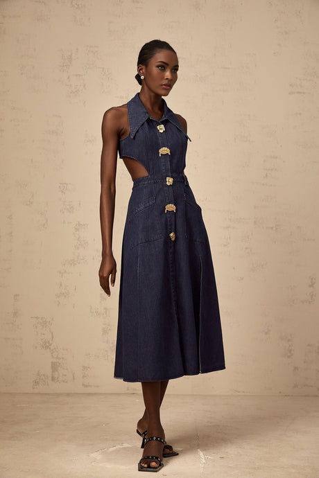 A dark blue denim midi dress with cut out details on a white background