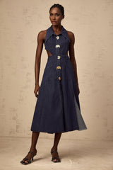 A dark blue denim midi dress with cut out details on a white background