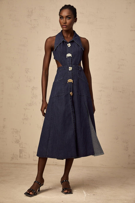 A dark blue denim midi dress with cut out details on a white background