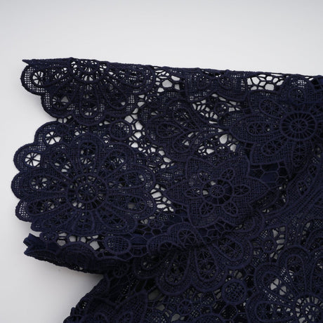 A dark blue midi dress with a floral crochet lace pattern covering the entire garment
