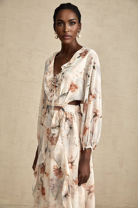 A floral print midi dress with an open waist design featuring a colorful pattern on a light background The dress has a feminine silhouette with a flowing skirt and likely includes details such as short sleeves or straps
