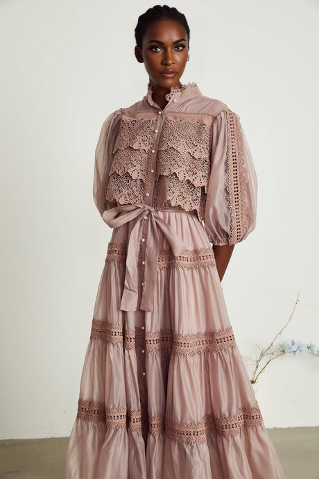 A flowy tiered midi dress with lace details and cutout design featuring a feminine silhouette in a soft color palette