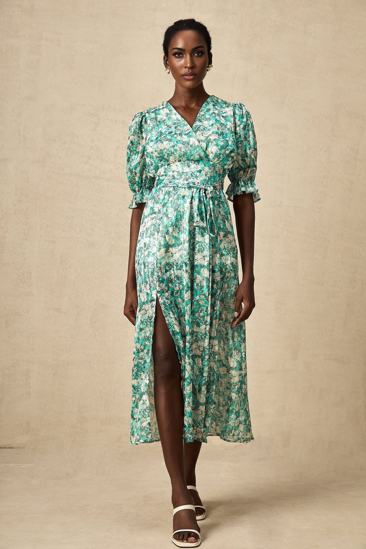 A green midi dress with floral print and high slit featuring a feminine silhouette