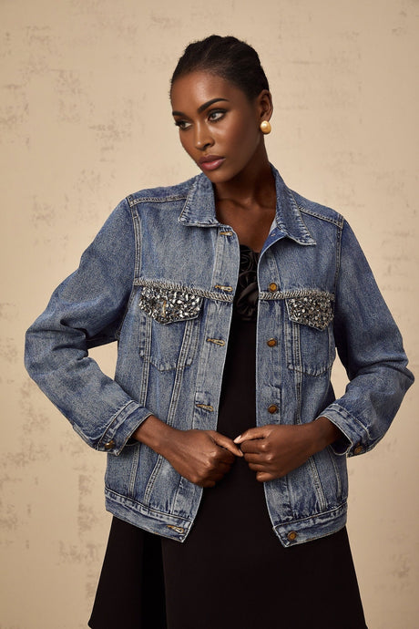 A light blue denim jacket adorned with sparkling rhinestones featuring a feminine and glamorous design