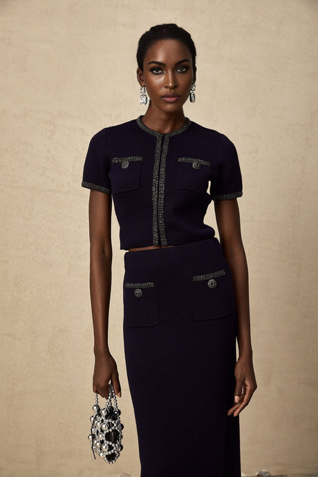 A matching set consisting of a ribbed knit top and skirt with embellishments called Aida The top and skirt feature a textured knit pattern and decorative details The set is designed to be worn together as a coordinated outfit