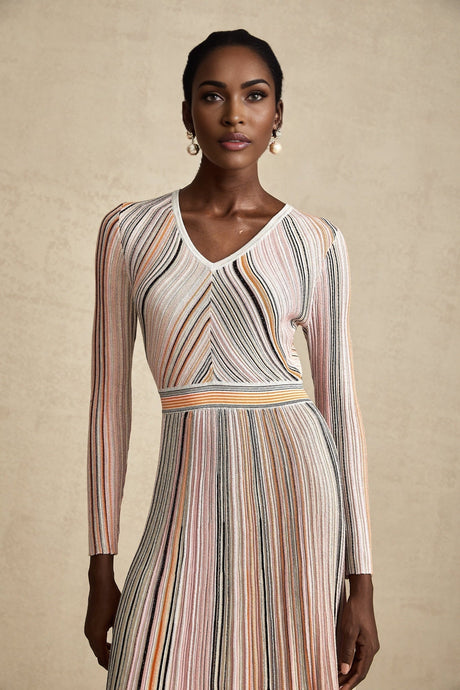 A pink metallic pleated midi dress with a shimmering finish named Mathilde featuring a flowing skirt that falls to mid calf length