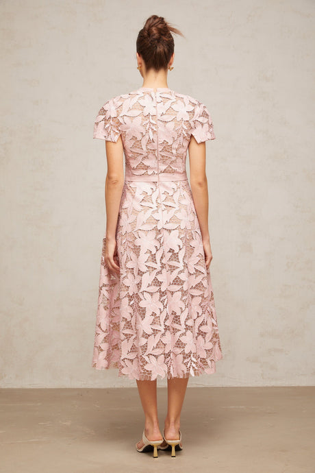 A pink midi dress made of delicate guipure lace featuring intricate floral patterns and a feminine silhouette