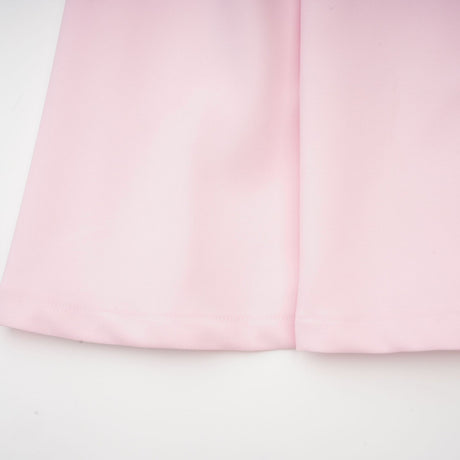 A pink midi dress with a bow detail and crystal accents inspired by the Cassiopeia constellation