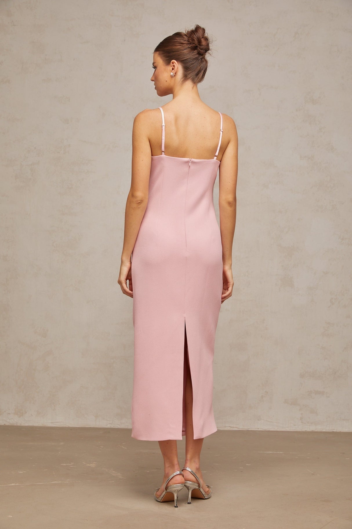 A pink midi dress with a corsetstyle bodice adorned with crystal embellishments featuring a feminine silhouette and elegant design