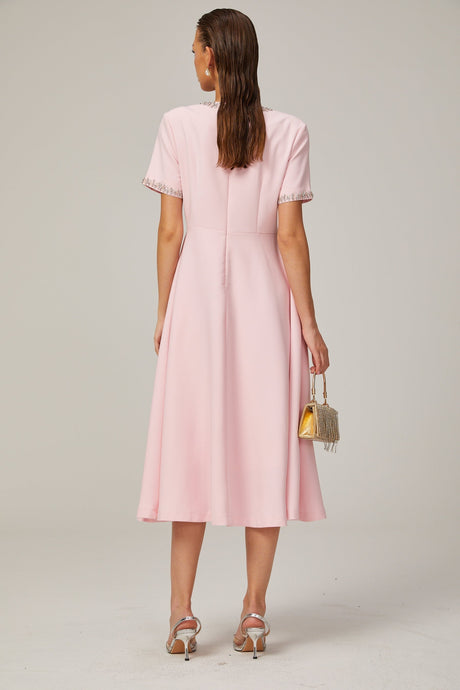 A pink midi dress with a crystalaccented bow and a Cassiopeiainspired design