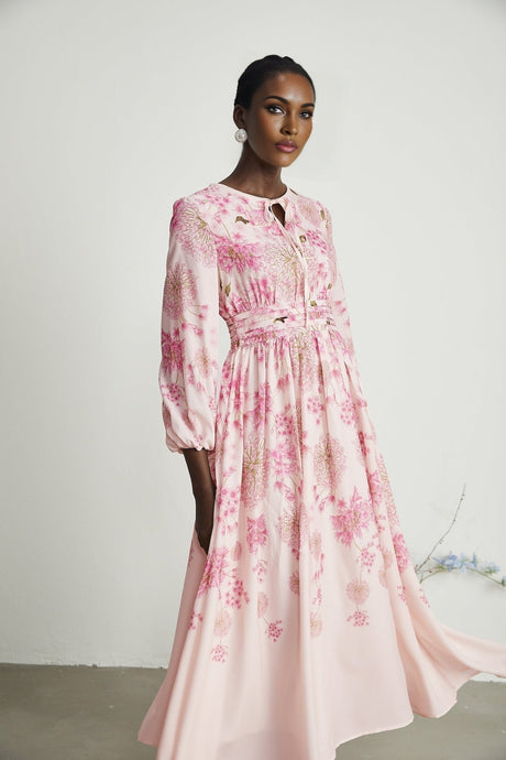 A pink midi dress with a floral print pattern covering the fabric Yvette dress shown on a white background