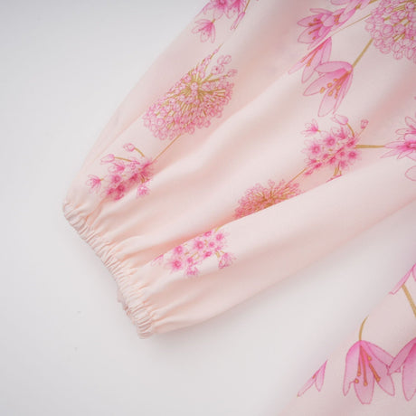 A pink midi dress with a floral print pattern featuring a design by Yvette