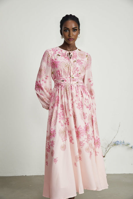 A pink midi dress with a floral print pattern featuring a design by Yvette