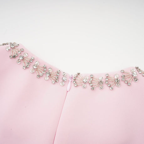 A pink midi dress with a large bow accent and crystal embellishments inspired by the Cassiopeia constellation