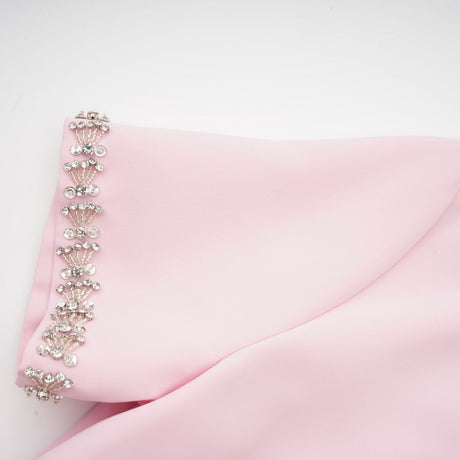 A pink midi dress with a large bow detail adorned with crystal accents inspired by the Cassiopeia constellation