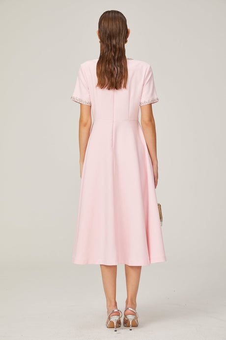 A pink midi dress with a large bow detail and crystal accents inspired by the Cassiopeia constellation