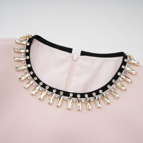 A pink midi dress with crystal embellishments and color blocking featuring a design inspired by Anais