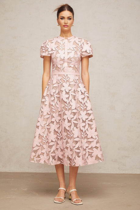 A pink midi dress with delicate guipure lace detailing and a feminine silhouette