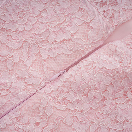 A pink midi dress with floral embroidery and lace details featuring embellishments and a feminine silhouette