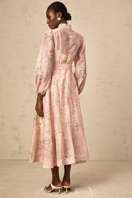 A pink midi dress with floral print and embellishments featuring a fitted bodice and flowing skirt