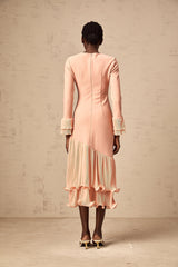 A pink midi dress with ruffled trim and paneled design featuring a flowy silhouette and feminine details
