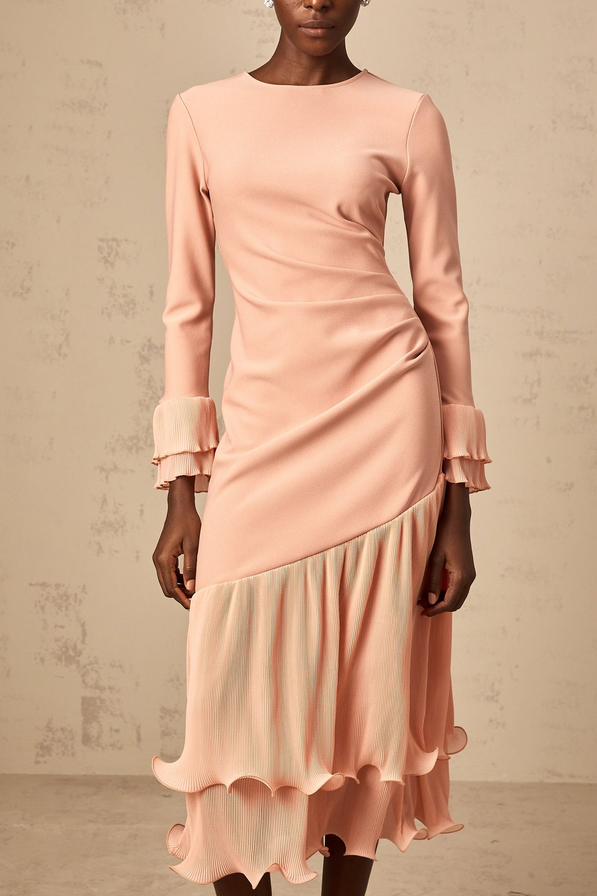 A pink midi dress with ruffled trim and paneled design featuring a flowy silhouette and feminine details