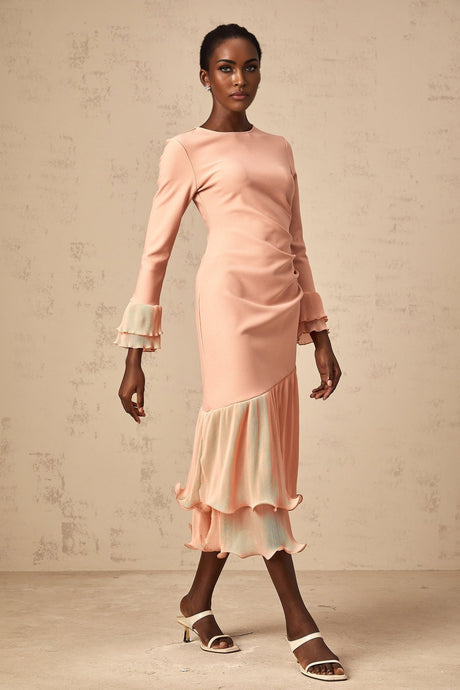 A pink midi dress with ruffled trim and paneled design featuring a flowy silhouette and feminine details