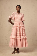 A pink midi dress with ruffled tulle featuring small dot details and a flowy silhouette