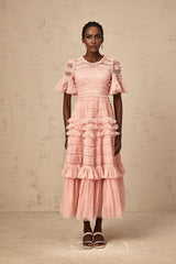 A pink midi dress with ruffles and tulle fabric featuring small dot details throughout the design