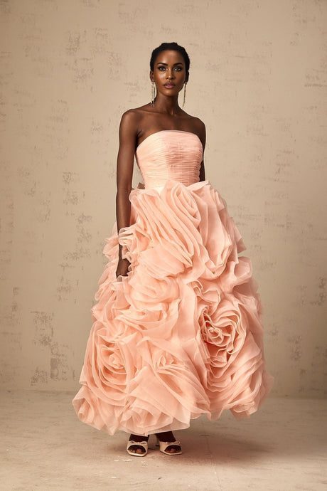 A pink offshoulder midi dress with 3D petal details made of tulle fabric The dress has a fitted bodice and flares out to a full skirt reaching midcalf length