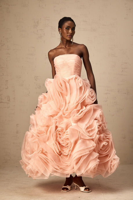 A pink offshoulder midi dress with 3D tulle petals adorning the bodice and skirt creating a romantic and textured appearance