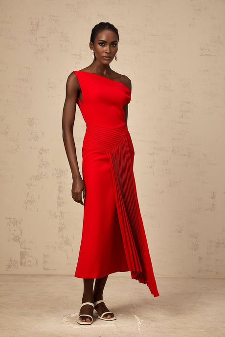 A red asymmetric draped midi dress with an uneven hemline and flowing fabric styled on a model against a plain background