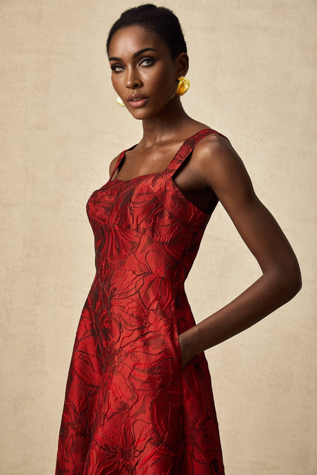 A red midi dress with a floral jacquard pattern featuring a fitted silhouette and long sleeves