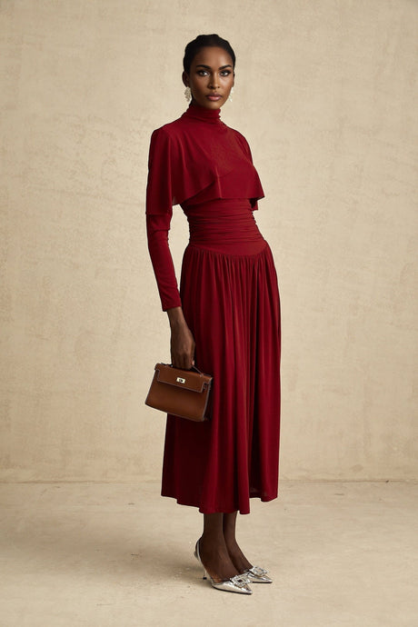 A red midi dress with ruched detailing and a flap design named Camille