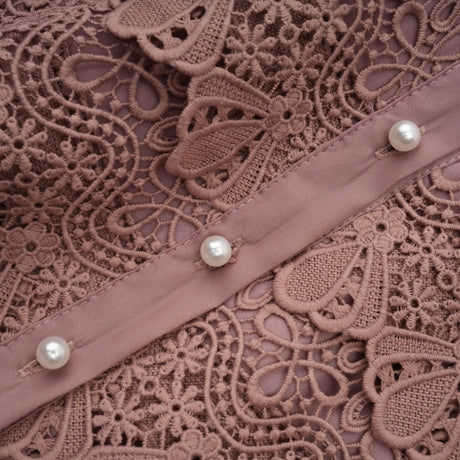 A tiered midi dress with lace detailing and cut out sections featuring a feminine silhouette and delicate design
