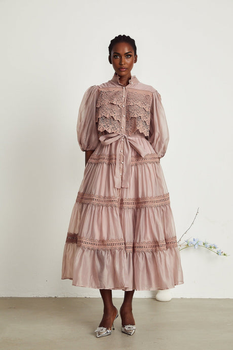 A tiered midi dress with lace detailing and cut out sections featuring a feminine silhouette in a delicate design