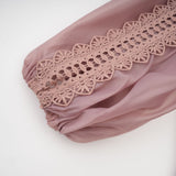 A tiered midi dress with lace details and cut out sections featuring a feminine and elegant design