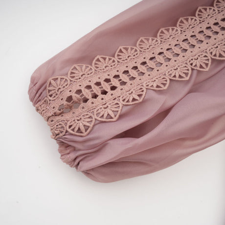 A tiered midi dress with lace details and cut out sections featuring a feminine and elegant design